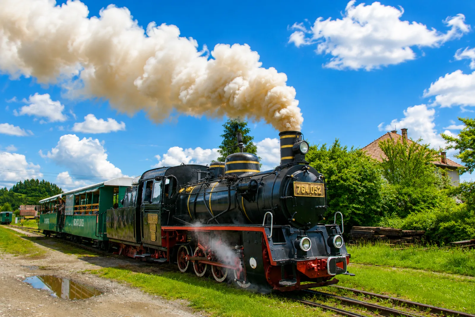 Locomotiva cu aburi 764.052 în gară, sub cer albastru